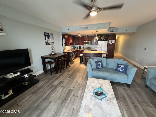 9902 S Thomas Dr Unit 636, Panama City Beach, FL 32408 - living area featuring baseboards, light wood-style flooring, and a ceiling fan