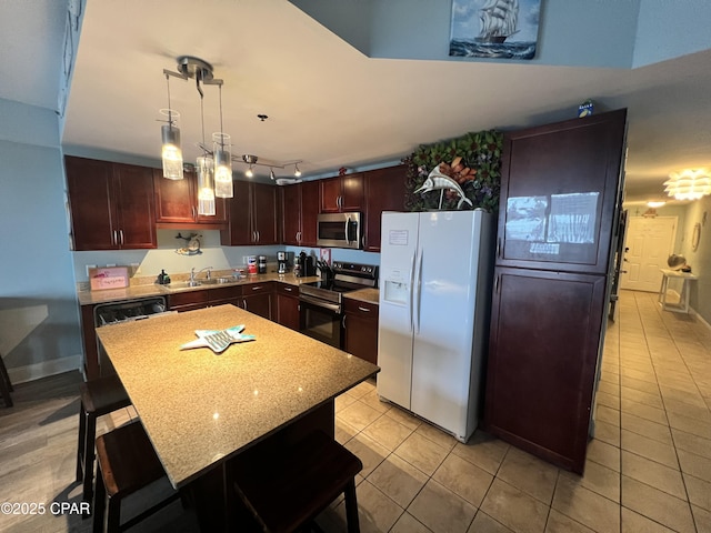 9902 S Thomas Dr Unit 636, Panama City Beach, FL 32408 - kitchen featuring appliances with stainless steel finishes, light tile patterned flooring, a sink, a breakfast bar, and a center island