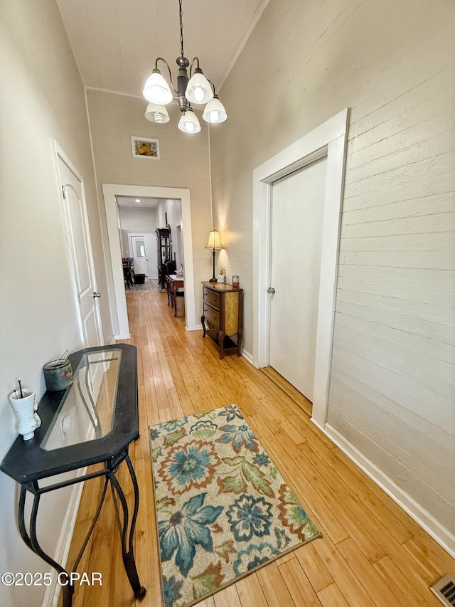 5382 10th St, Malone, FL 32445 - hallway with light wood-type flooring, a chandelier, and a high ceiling