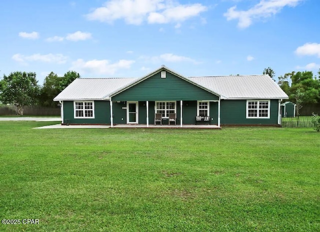 21382 NW Paradise Ln, Altha, FL 32421 - rear view of house with metal roof, a lawn, and covered porch