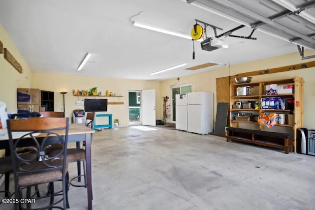 21382 NW Paradise Ln, Altha, FL 32421 - garage featuring freestanding refrigerator and a garage door opener