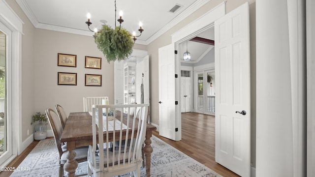 24197 NW Pine Tree Trl, Fountain, FL 32438 - dining space featuring wood finished floors, healthy amount of natural light, a chandelier, and crown molding