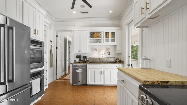 24197 NW Pine Tree Trl, Fountain, FL 32438 - kitchen with stainless steel appliances, a ceiling fan, light tile patterned flooring, white cabinets, and crown molding