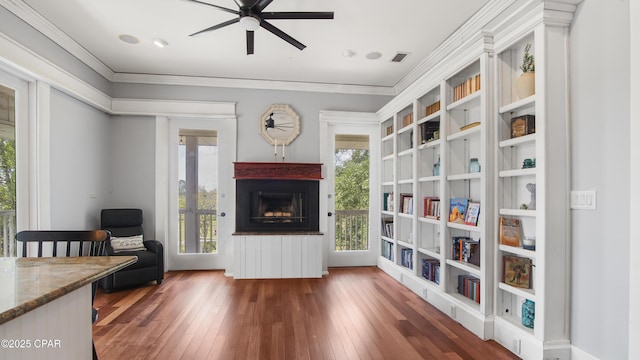 24197 NW Pine Tree Trl, Fountain, FL 32438 - sitting room featuring a fireplace, wood-type flooring, a ceiling fan, plenty of natural light, and ornamental molding