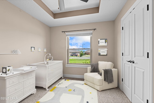 4304 Bylsma Cir, Panama City, FL 32404 - bedroom with a nursery area, baseboards, ceiling fan, a tray ceiling, and a closet