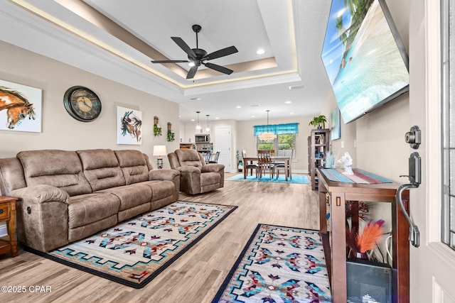 4304 Bylsma Cir, Panama City, FL 32404 - living room with ceiling fan, light wood-style floors, a raised ceiling, and recessed lighting