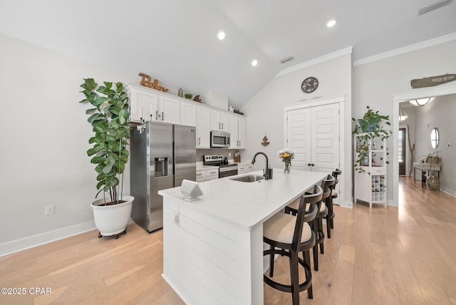 2012 Frankford Point Rd, Panama City, FL 32405 - kitchen with appliances with stainless steel finishes, a sink, a center island with sink, white cabinets, and ornamental molding