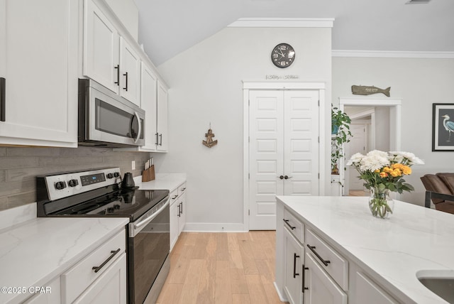 2012 Frankford Point Rd, Panama City, FL 32405 - kitchen featuring stainless steel appliances, tasteful backsplash, light stone counters, white cabinets, and light wood-type flooring