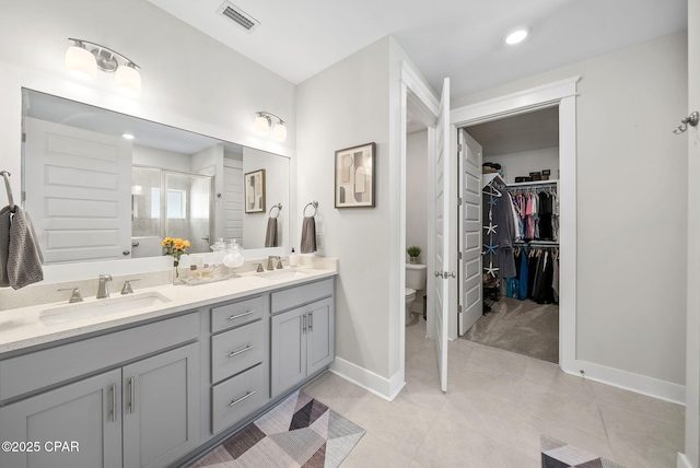 2012 Frankford Point Rd, Panama City, FL 32405 - bathroom with toilet, double vanity, a shower stall, baseboards, and a spacious closet