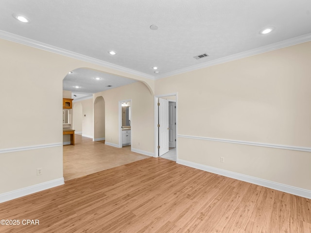 1406 New Jersey Ave, Lynn Haven, FL 32444 - empty room featuring arched walkways, light wood finished floors, crown molding, baseboards, and recessed lighting