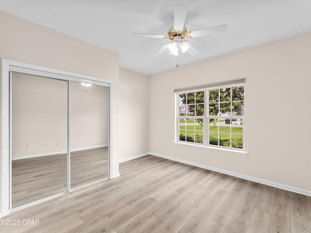 1406 New Jersey Ave, Lynn Haven, FL 32444 - unfurnished bedroom with wood finished floors, a closet, baseboards, and a ceiling fan