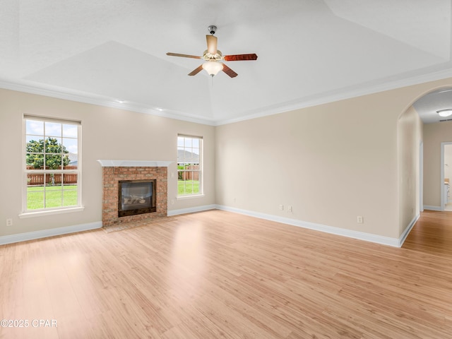 1406 New Jersey Ave, Lynn Haven, FL 32444 - unfurnished living room featuring a tray ceiling, light wood-style floors, arched walkways, healthy amount of natural light, and ornamental molding