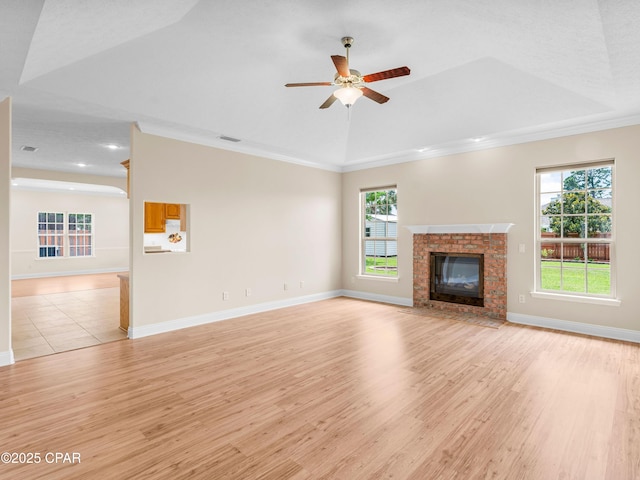 1406 New Jersey Ave, Lynn Haven, FL 32444 - unfurnished living room with light wood-style floors, a ceiling fan, healthy amount of natural light, a brick fireplace, and crown molding