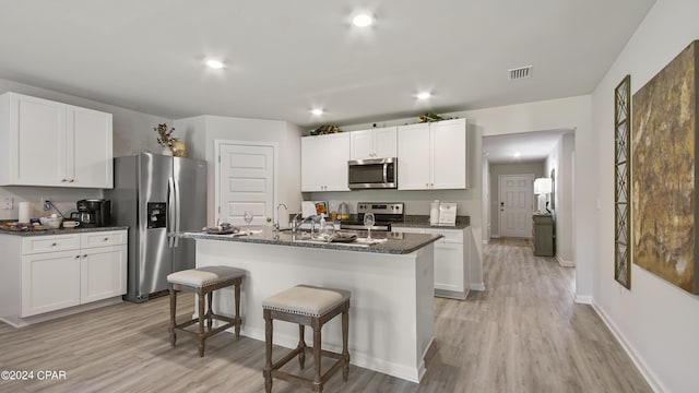 4132 Concord Blvd, Chipley, FL 32428 - kitchen featuring stainless steel appliances, light wood-style floors, a kitchen bar, white cabinets, and recessed lighting