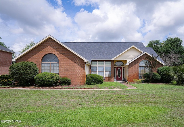 2712 Woodmere Dr, Panama City, FL 32405 - ranch-style house with brick siding, a front yard, and roof with shingles