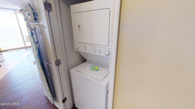 16819 Front Beach Rd Unit 903, Panama City Beach, FL 32413 - laundry room featuring stacked washer / drying machine, a textured wall, and wood finished floors