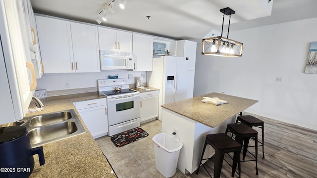 9860 S Thomas Dr Unit 1519, Panama City, FL 32408 - kitchen with white appliances, a sink, a kitchen bar, and white cabinetry