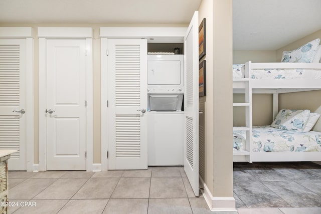 11807 Front Beach Rd Unit 1-706, Panama City Beach, FL 32407 - bedroom featuring stacked washing machine and dryer, light tile patterned floors, and multiple closets