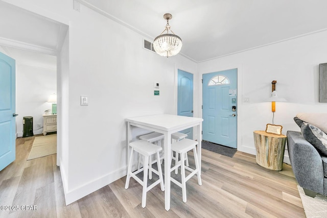 17462 Front Beach Rd Unit 11C1, Panama City Beach, FL 32413 - dining area featuring light wood finished floors, a chandelier, baseboards, and ornamental molding