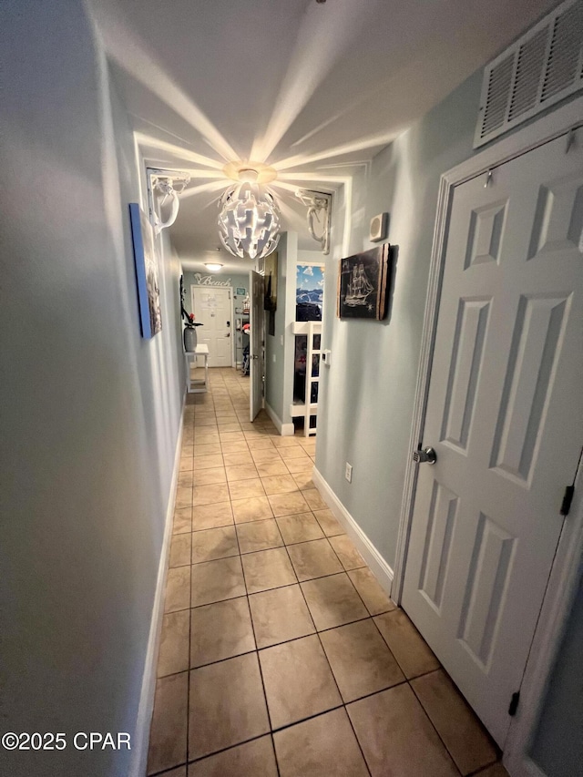 9902 S Thomas Dr Unit 237, Panama City Beach, FL 32408 - corridor with light tile patterned floors, a chandelier, and baseboards