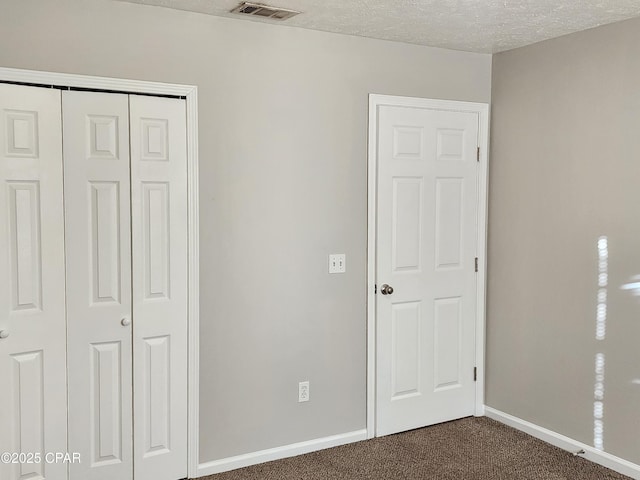 5432-5434 Sunset, Panama City, FL 32408 - unfurnished bedroom with dark carpet, a closet, baseboards, and a textured ceiling
