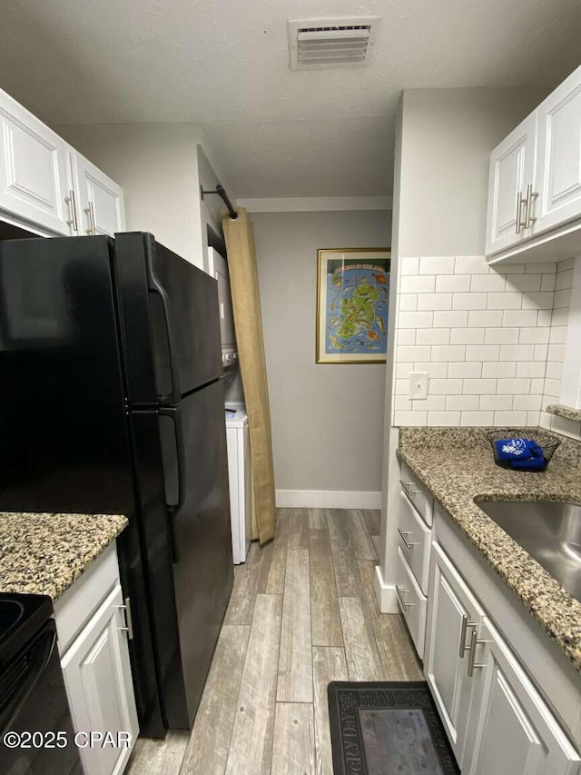 17214 Front Beach Rd Unit G-4, Panama City Beach, FL 32413 - kitchen with decorative backsplash, light wood-type flooring, baseboards, white cabinets, and crown molding