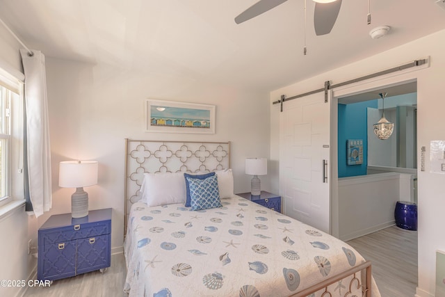 17735 Front Beach Rd Unit 2, Panama City Beach, FL 32413 - bedroom featuring wood finished floors, a barn door, baseboards, and ceiling fan
