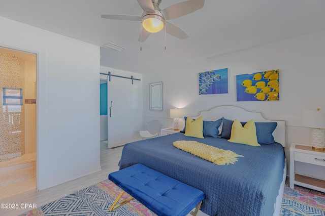 17735 Front Beach Rd Unit 2, Panama City Beach, FL 32413 - bedroom with a barn door, wood finished floors, a ceiling fan, and ensuite bathroom