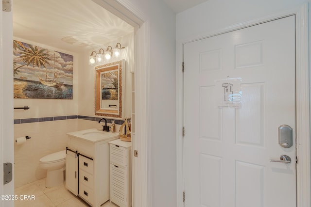 17735 Front Beach Rd Unit 2, Panama City Beach, FL 32413 - bathroom featuring vanity, tile walls, toilet, a wainscoted wall, and tile patterned floors