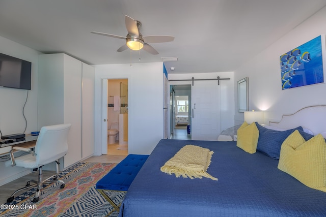 17735 Front Beach Rd Unit 2, Panama City Beach, FL 32413 - bedroom featuring a barn door, a ceiling fan, wood finished floors, and ensuite bath