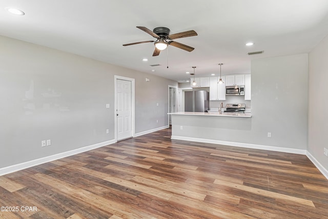 3729 E 9th St, Panama City, FL 32401 - unfurnished living room with recessed lighting, a ceiling fan, baseboards, dark wood finished floors, and a sink