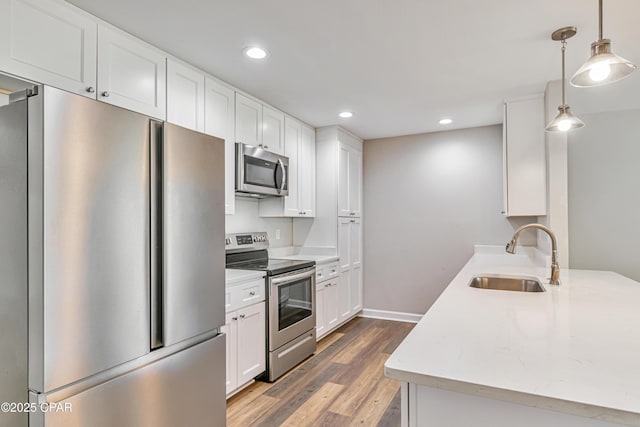 3729 E 9th St, Panama City, FL 32401 - kitchen with stainless steel appliances, a sink, light wood-type flooring, white cabinetry, and recessed lighting