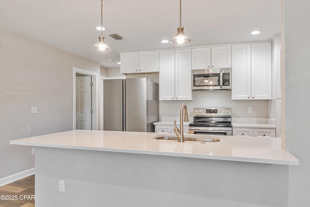 3729 E 9th St, Panama City, FL 32401 - kitchen with appliances with stainless steel finishes, a sink, white cabinetry, dark wood-type flooring, and recessed lighting