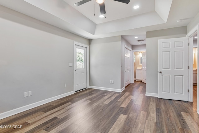 3729 E 9th St, Panama City, FL 32401 - unfurnished bedroom with baseboards, dark wood-style floors, a raised ceiling, connected bathroom, and recessed lighting