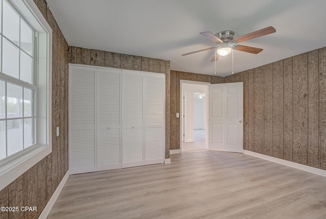 25966 George Maloy Ln, Altha, FL 32421 - unfurnished bedroom featuring light wood-style floors, a closet, baseboards, and ceiling fan
