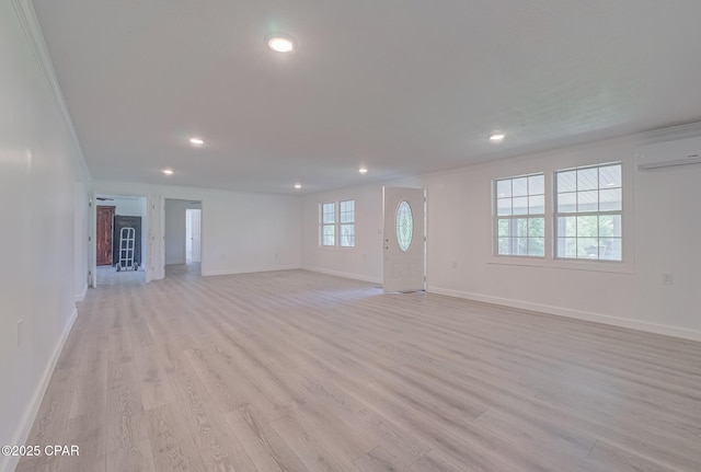 25966 George Maloy Ln, Altha, FL 32421 - unfurnished living room with light wood-type flooring, baseboards, recessed lighting, an AC wall unit, and crown molding