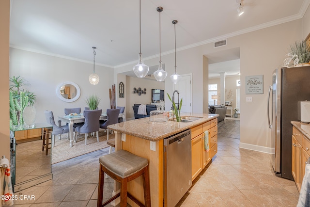 8700 Front Beach Rd Unit 8107, Panama City Beach, FL 32407 - kitchen featuring appliances with stainless steel finishes, a sink, ornamental molding, an island with sink, and light tile patterned floors