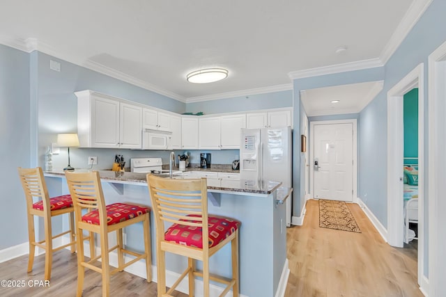 17545 Front Beach Rd Unit 2004, Panama City Beach, FL 32413 - kitchen featuring white appliances, a peninsula, light wood-type flooring, white cabinetry, and ornamental molding