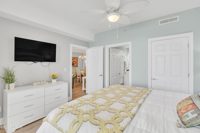 17545 Front Beach Rd Unit 2004, Panama City Beach, FL 32413 - bedroom with light wood finished floors, a chandelier, ceiling fan, and ensuite bathroom