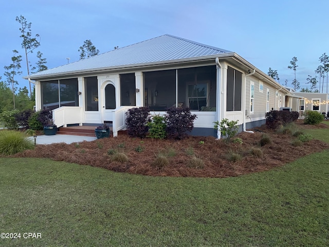 290 Rudys Blaze, Wewahitchka, FL 32465 - view of front of house featuring a sunroom, a front lawn, and metal roof