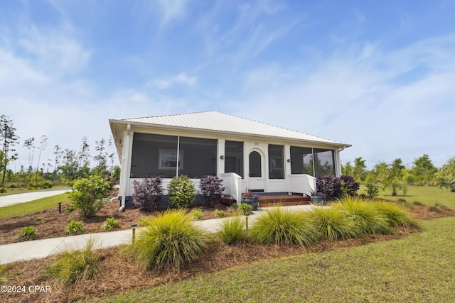 290 Rudys Blaze, Wewahitchka, FL 32465 - view of front of house with a sunroom, a front yard, and metal roof