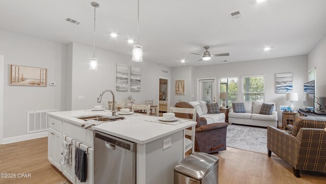 113 Mosaic Dr, Port St Joe, FL 32456 - kitchen featuring stainless steel dishwasher, light wood finished floors, ceiling fan, a sink, and an island with sink
