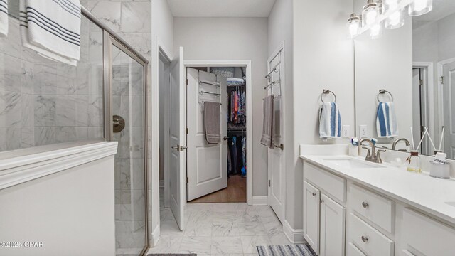 113 Mosaic Dr, Port St Joe, FL 32456 - full bath with marble look tile flooring, a stall shower, double vanity, a walk in closet, and baseboards