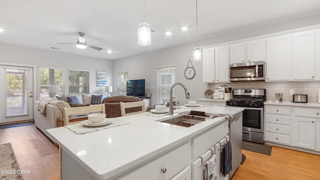 113 Mosaic Dr, Port St Joe, FL 32456 - kitchen featuring stainless steel appliances, a kitchen island with sink, a sink, white cabinets, and open floor plan