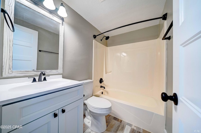823 Bradley Cir, Lynn Haven, FL 32444 - bathroom featuring wood finished floors, vanity, washtub / shower combination, toilet, and a textured ceiling