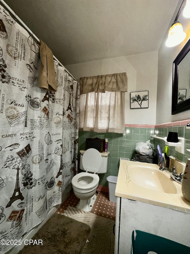 2958 Russ St, Marianna, FL 32446 - full bathroom with vanity, toilet, tile walls, a shower with shower curtain, and wainscoting