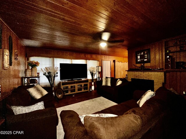 2958 Russ St, Marianna, FL 32446 - living area featuring wood ceiling, ceiling fan, wooden walls, wood finished floors, and a brick fireplace