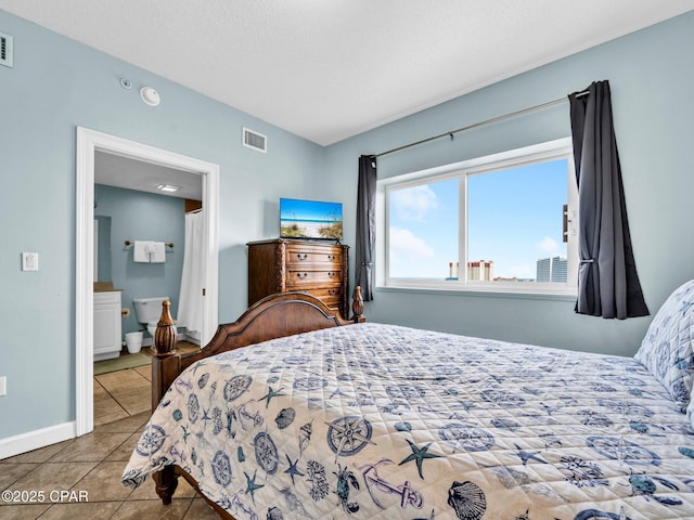 9450 S Thomas Dr Unit 1211, Panama City, FL 32408 - tiled bedroom featuring baseboards and connected bathroom