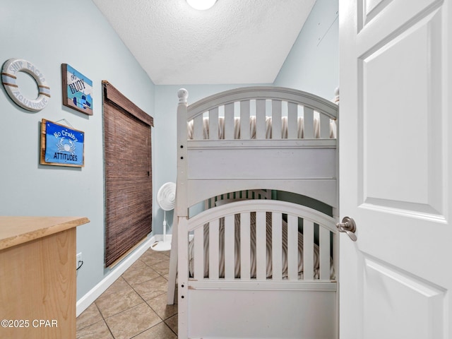 9450 S Thomas Dr Unit 1211, Panama City, FL 32408 - bedroom featuring a textured ceiling, light tile patterned flooring, and baseboards
