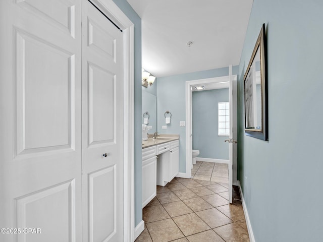9450 S Thomas Dr Unit 1211, Panama City, FL 32408 - bathroom with toilet, vanity, baseboards, tile patterned flooring, and a closet